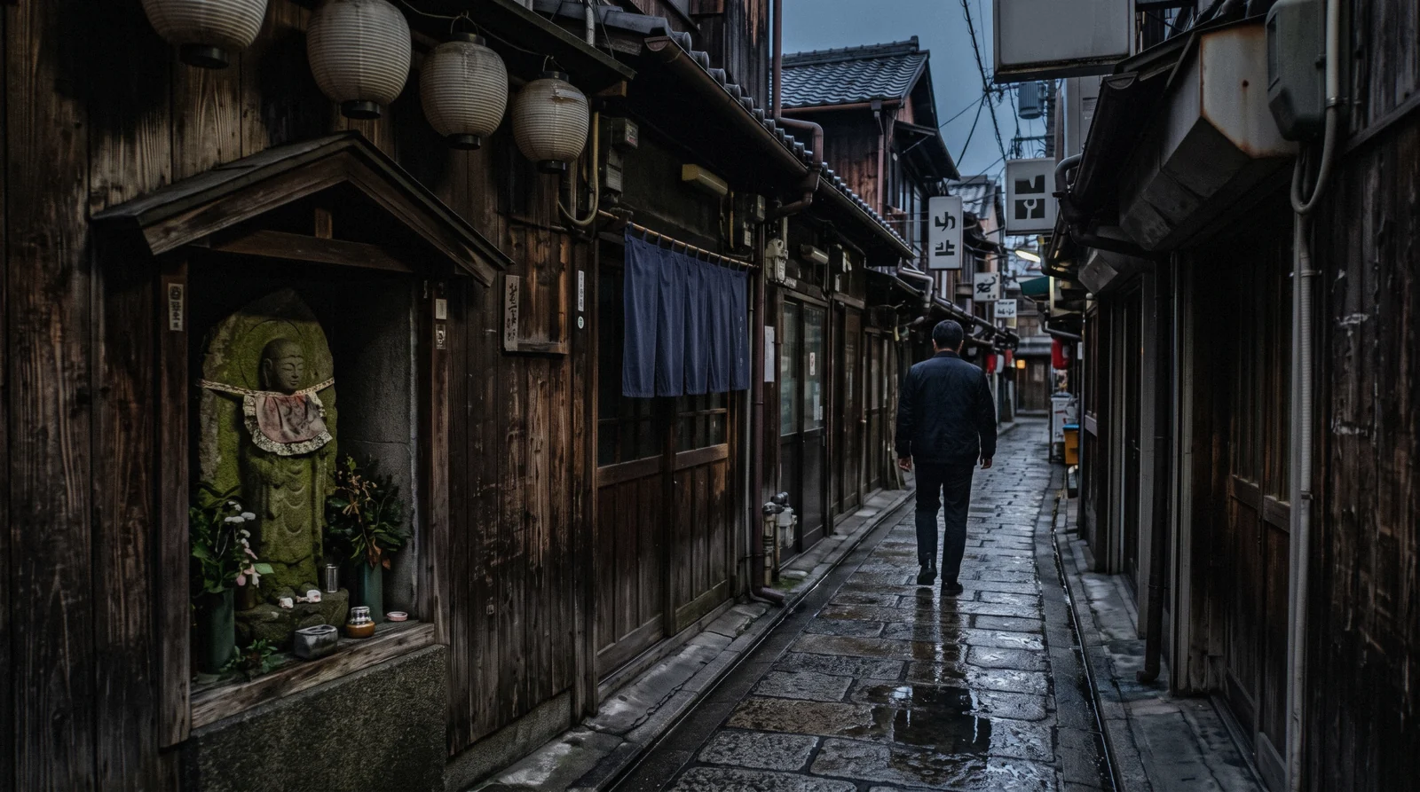 Lanterns and flagstones along the narrow Hozenji Yokocho alley at dusk, Osaka Japan