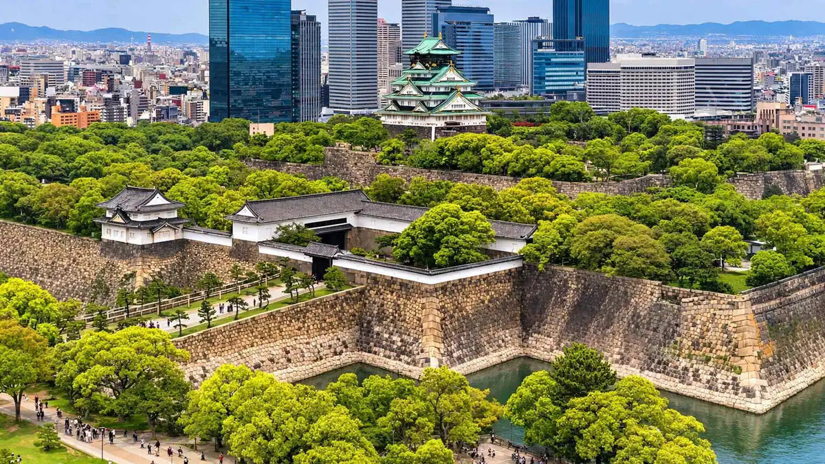 Group crossing the moat bridge towards Osaka Castle on a guided walking tour of the top sights, Osaka Japan