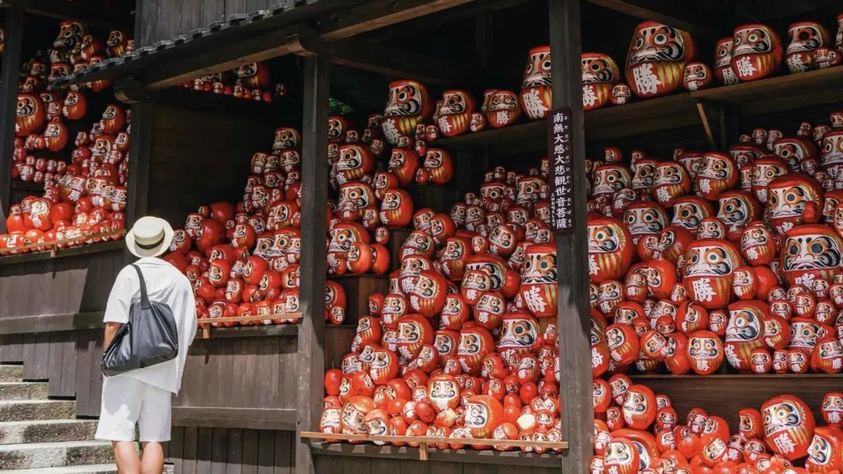 Rows of red daruma dolls on the steps at Katsuo-ji Temple on a day trip from Osaka, Osaka Japan
